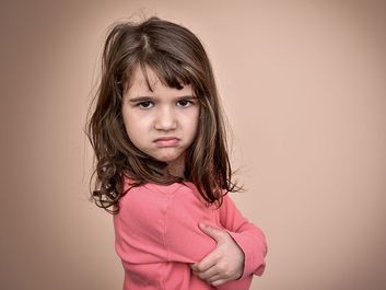 Frowning little girl. Angry annoyed