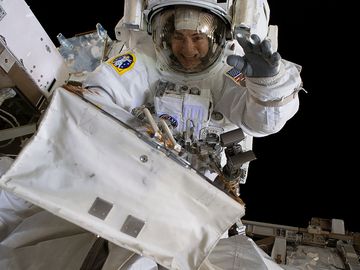 October 18, 2019. NASA astronaut Jessica Meir waves at the camera during a spacewalk with fellow NASA astronaut Christina Koch (out of frame). They ventured into the vacuum of space for seven hours and 17 minutes to swap a failed battery charge-discharge unit (BCDU) with a spare during the first all-woman spacewalk. The BCDU regulates the charge to the batteries that collect and distribute solar power to the orbiting lab's systems.