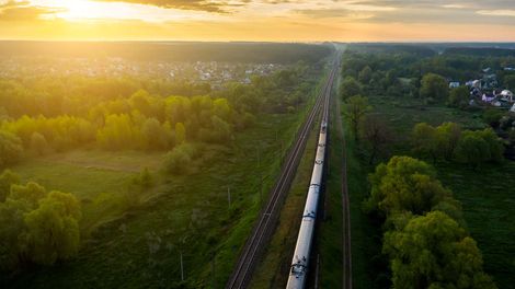 A photo of a train headed along its track toward the sunset.