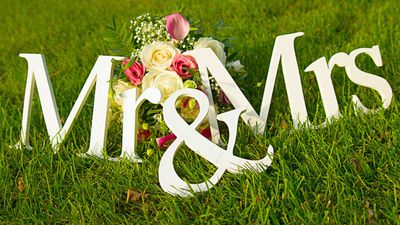 Sign for wedding "Mr & Mrs" (mister and missis) with flowers in the grass